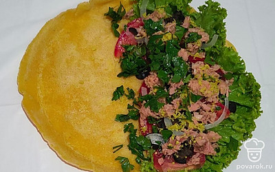 Очистите и нарежьте лук полукольцами, помидоры - дольками, маслины порежьте кусочками, натрите цедру лимона, петрушку мелко порежьте. Консервированную рыбу разомните вилкой. На готовую лепешку выложите листья салата, затем немного порезанного лука, филе тунца, маслины, помидоры, цедру лимона и зелень петрушки по вашему желанию. Поперчите по вкусу, сбрызните соком лимона и скрутите в рулет.