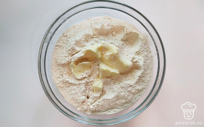 Смешайте слегка подтаявшее сливочное масло с мукой, разотрите руками в крошку. Влейте понемногу теплую воду, добавляйте постепенно, возможно, ее понадобится меньше, если качество муки хорошее. Вымешивайте тесто 5-7 минут. Разделите на 6-8 частей, дайте отдохнуть 9-12 минут.