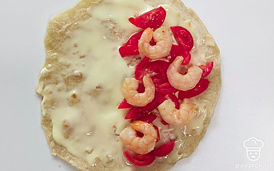 Обжарьте на сливочном масле сначала креветки, не более 3 минут, затем помидоры. Они должны стать немного мягче. Лепешку смажьте сливочным сыром, выложите помидоры, обжаренные на сливочном масле, креветки, накройте листом салата, сложите пополам.