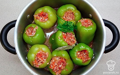 Начините фаршем перец, уложите в кастрюлю и влейте 2 стакана воды. Доведите до кипения и продолжайте готовить еще 40-50 минут.