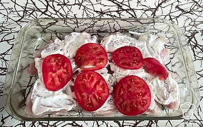 Покройте сверху сметаной и добавьте порезанные на дольки помидоры.