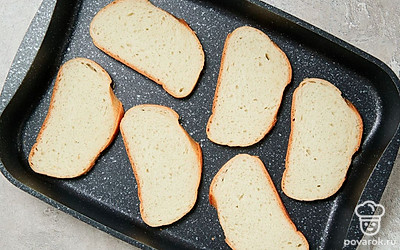 Подготовьте хлеб к запеканию. Хлеб нарежьте тонкими ломтиками, разложите на противне.