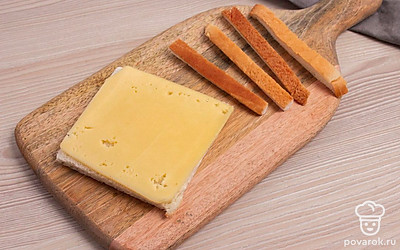 С хлебушка отрежьте корочки со всех сторон. На получившийся квадрат, положите отрезанный тонким слоем сыр.