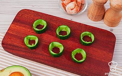 Огурец порежьте на кружочки, толщиной 2 см и аккуратно выньте из каждого серединку. Сформировав колечки.