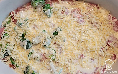 Посолить. Залить взбитыми яйцами со сметаной и мукой. Посыпать тертым сыром. Накрыть форму фольгой. Запекать примерно 40-50 минут, до готовности.