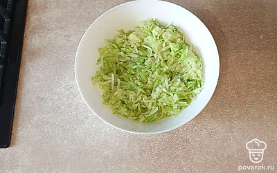 Кабачок помойте и натрите на крупной терке. Оставшуюся половину соли перемешайте и отставьте минут на десять. Нужно, чтобы кабачок пустил сок.