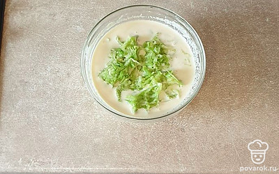 В сметанную смесь выложите сухой чеснок. Затем хорошо отожмите натертый кабачок и добавьте в сметанную заливку. Все перемешайте.