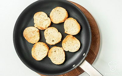 Обжарьте багет. Багет нарежьте на ломтики толщиной 1 см. Подсушите багет на сухой сковороде на среднем огне по 1 минуте с каждой стороны.