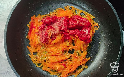 Обжарьте лук на разогретой сковороде до золотистого цвета. Затем добавьте морковь и продолжайте обжаривать еще несколько минут. Отправьте туда же томатную пасту, соль и перец. Тушите около 15 минут.