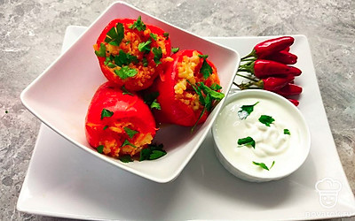 Готовый перец выложите на порционную тарелку. Украсьте блюдо веточкой свежей зелени и подавайте горячим с ложкой густой сметаны.