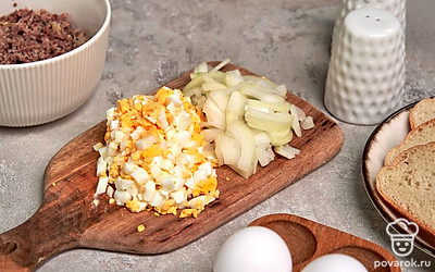 Подготовьте продукты для соуса. Отварите куриные желудки в подсоленной воде не меньше 60 минут. За 10 минут до конца варки положите лавровые листы. Откиньте желудки на дуршлаг и пропустите их через мясорубку. Измельчите яйца.