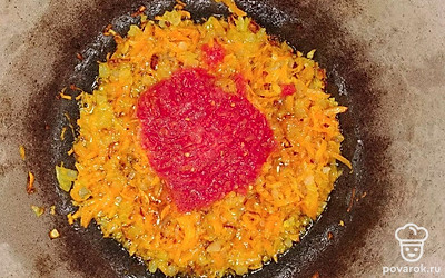 На растительном масле обжарьте луковые кубики до золотистого цвета. Добавьте морковь и жарьте еще 5 минут. Отправьте туда же томатную пасту и обжаривайте еще 5 минут.