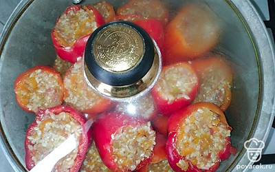 Наполните начинкой каждый перец, оставляя немного места сверху. В кастрюлю или казан поместите каждый перец и залейте подсоленной водой до середины. Добавьте 2 столовые ложки подсолнечного масла и накройте крышкой. Варите блюдо около 50 минут.