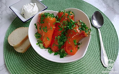 Уложите готовый перец по порционным тарелкам, присыпьте мелко порубленной зеленью на собственное усмотрение и подавайте в горячем виде.