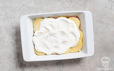 Смажьте верхний слой сметаной. Отправьте форму в разогретую духовку на 50 минут.