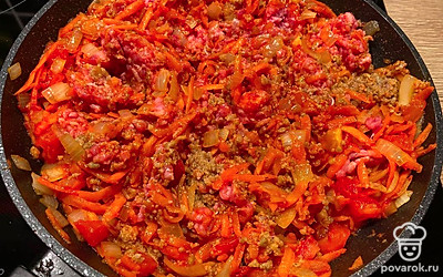 Обжарьте до золотистой корочки лук, добавьте морковь и томатную пасту, пассируйте 2-3 минуты. Затем добавьте фарш, и тушите еще 4 минуты.