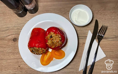 Фаршированный перец подавайте к столу в теплом виде. Полейте сметаной, или подайте в отдельной соуснице. Украсьте петрушкой или укропом.