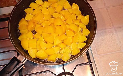 Картофель чистим, режем кубиком и выкладываем на сковороду. Обжариваем в течение 20 минут. 