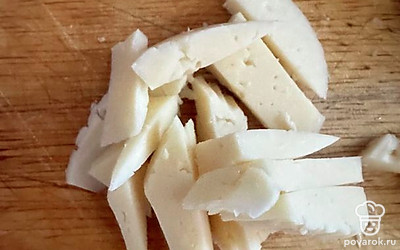 Нарезать сыр брусочками и выложить сверху. Дождаться, когда сыр расплавится.
