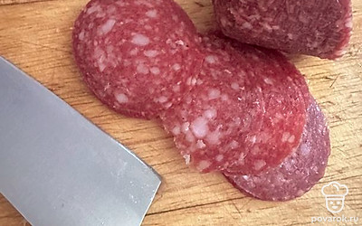 Нарезать колбасу кубиками.