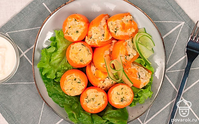 Нарежьте свежие огурцы кружочками. Выложите на тарелку для сервировки листья салата айсберг, сверху положите запеченные помидоры и дополните огурцами.