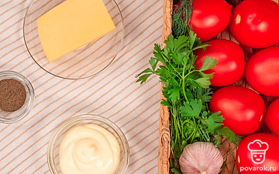 Помойте помидоры, почистите чеснок и пропустите его через специальный пресс. Мелко потрите сыр. Подготовьте плоское широкое блюдо для подачи закуски. Промойте и высушите зелень петрушки и укропа.