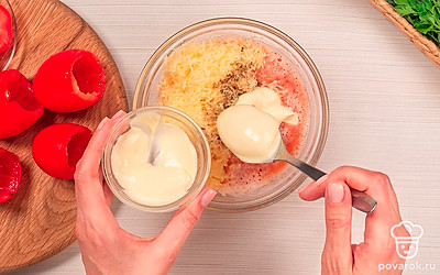 Сделайте начинку. Срежьте верхушку с каждого овоща и аккуратно вытащите мякоть при помощи ложки. Смешайте натертый сыр с измельченным чесноком и мякотью помидоров. Добавьте майонез и перец, а затем размешайте.