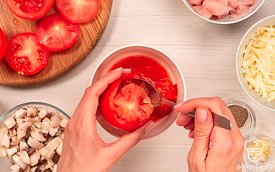 Подготовьте помидоры к фаршировке. Отрежьте у помидоров верхушки, выскоблите мякоть при помощи чайной ложки.