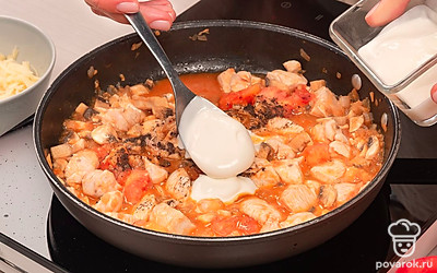 Приготовьте начинку. Разогрейте сковороду с растительным маслом и обжарьте лук в течение 3 минут. Выложите к луку чеснок и мякоть помидоров, перемешайте и готовьте еще 10 минут. Затем положите курицу и грибы, размешайте, убавьте огонь и протушите около 20 минут. Добавьте в начинку соль, перец и сметану, перемешайте и снимите с огня.