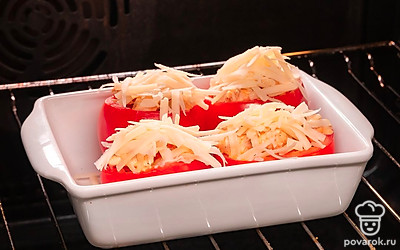 Запеките помидоры с курицей. Включите духовку на 200 градусов. Нафаршируйте помидоры начинкой из курицы, овощей и сметаны. Щедро посыпьте помидоры сыром и переложите их в форму для запекания. Поставьте форму в духовку и запекайте помидоры 20 минут.