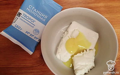 В тарелку выложите творог, добавьте желток куриного яйца. Хорошо перемешайте. 