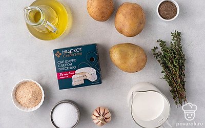 Тщательно промойте картофель. Вымойте и почистите чеснок. Подготовьте сотейник и круглую керамическую форму для запекания с невысокими бортиками. Смажьте форму растительным маслом. Разогрейте духовку до 180°С.