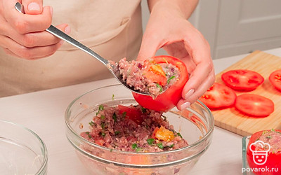 Подготовьте помидоры. Срежьте верх у каждого помидора, извлеките ложкой мякоть и смешайте ее с фаршем. Наполните помидоры начинкой, посыпьте густым слоем сыра и закройте "крышечками" — срезанными верхушками помидоров.