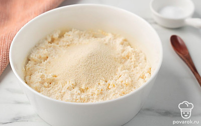 Положите в творог манную крупу и ванилин. Снова перемешайте.