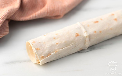 Сверните лаваш плотным рулетом.