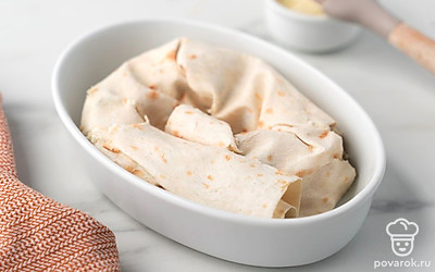 Смажьте форму для запекания сливочным маслом. Скрутите рулет из лаваша в виде улитки и положите в форму для запекания.