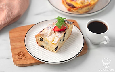 Посыпьте запеканку сахарной пудрой и нарежьте на порции. Украсьте порцию клубникой и мятой.