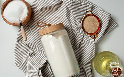 Муку просейте. Воду нагрейте до 40 градусов. Подготовьте чистые хлопковые полотенца, пищевую пленку, пергамент для выпечки и две формы для запекания. Разогрейте духовку до 180 градусов.