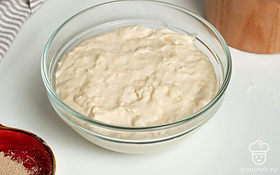 Приготовьте опару и замесите тесто. В теплую воду засыпьте дрожжи, тщательно перемешайте. Добавьте соль и растительное масло. Оставьте на 20 минут. Постепенно введите в опару муку и замесите жидкое липкое тесто. Накройте тесто пищевой пленкой и оставьте на 30 минут при комнатной температуре.