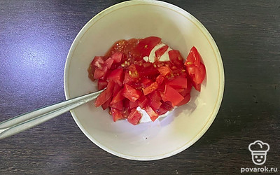 Добавьте к сметане мелко нарезанный помидор. 