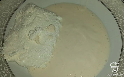 В глубокую емкость налейте ряженку и добавьте творог.