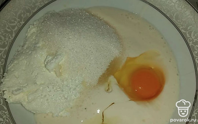 Разбейте одно куриное яйцо, насыпьте сахар. Перемешайте до однородной консистенции.