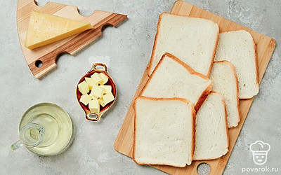 Нарежьте хлеб и сыр ломтиками. Разогрейте на сковороде растительное масло.