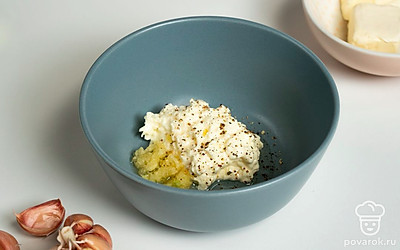 Приготовьте начинку. Чеснок пропустите через пресс. Смешайте растительное и сливочное масло с чесноком и перцем.