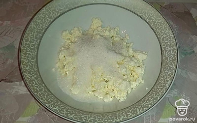 В глубокую миску выложите творог, добавьте сахарный песок, перетрите.