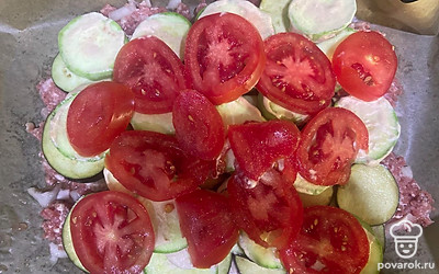 На кабачки выложите помидоры, нарезанные кружочками.