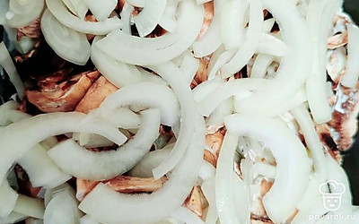 Белый лук нарежьте полукольцами. Выложите на грибы. Форму накройте фольгой и поставьте в духовку на 20-30 минут при 180-200 градусах.