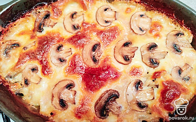 Через 20 минут достаньте форму, посыпьте тертым сыром, украсьте шампиньонами. Поставьте, не накрывая, еще на 10-15 минут в духовку.