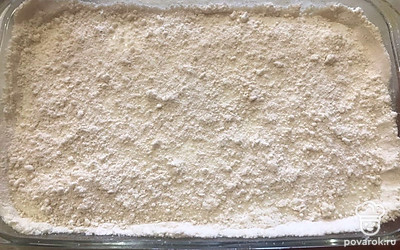 На противень выложите рассыпчатое тесто. Распределите его по поверхности.