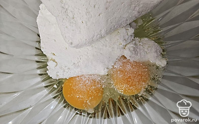 В отдельной емкости смешайте творог, яйца и посолите по вкусу. Перемешайте до однородной консистенции. 